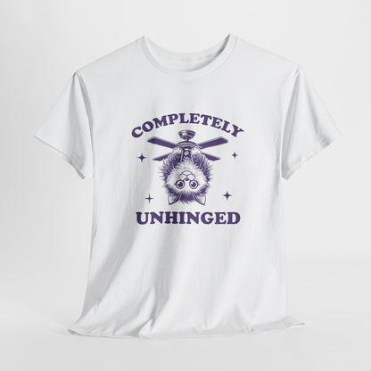 Hanging white T-shirt featuring "Completely Unhinged" text with a cat hanging upside down from a ceiling fan in navy blue-tone design. Part of the Vivid Divergence Sensory Friendly Unisex Tees Range.