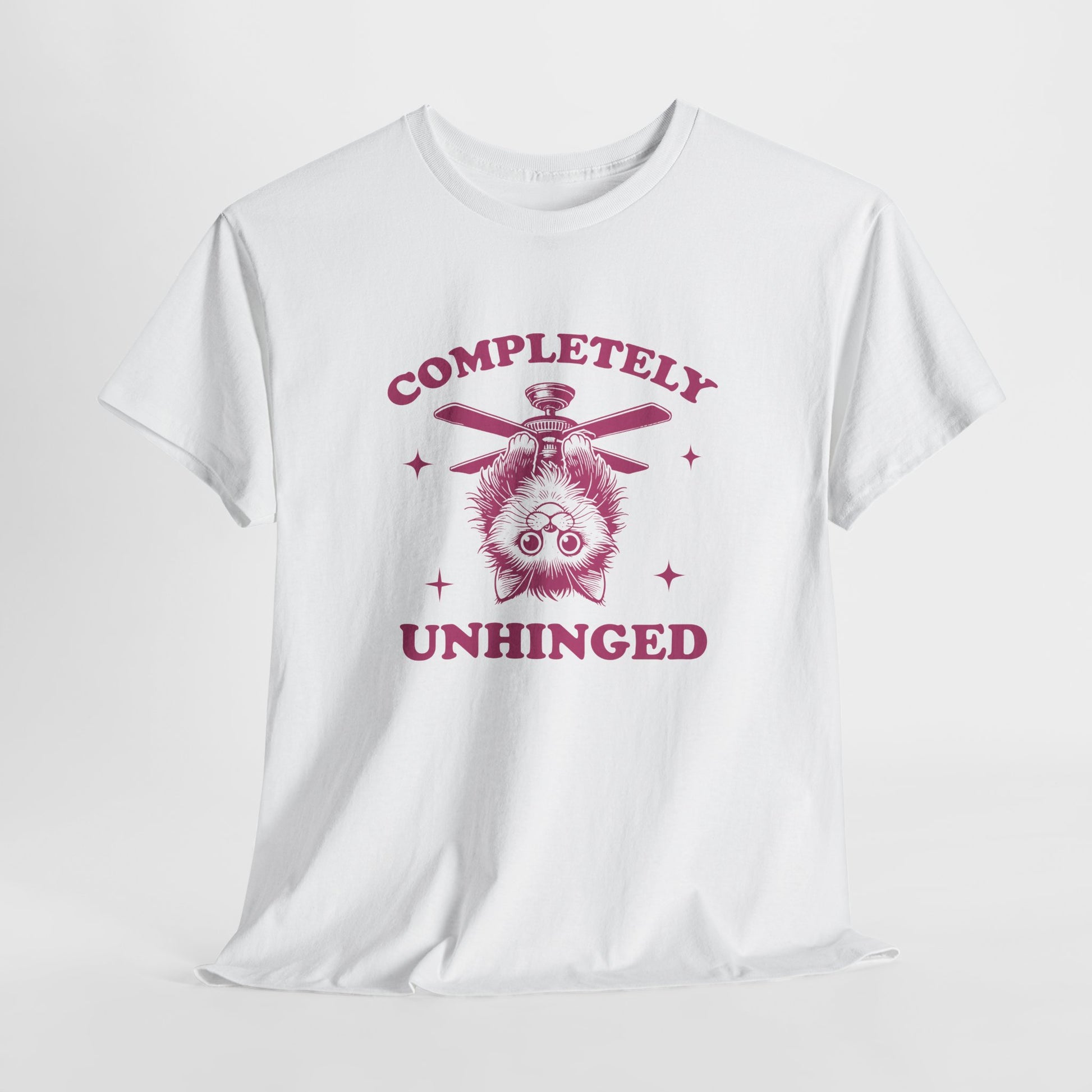 Hanging white T-shirt featuring "Completely Unhinged" text with a cat hanging upside down from a ceiling fan in red-tone design. Part of the Vivid Divergence Sensory Friendly Unisex Tees Range.