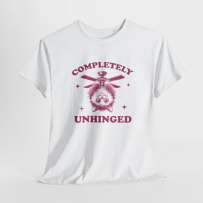 Hanging white T-shirt featuring "Completely Unhinged" text with a cat hanging upside down from a ceiling fan in red-tone design. Part of the Vivid Divergence Sensory Friendly Unisex Tees Range.