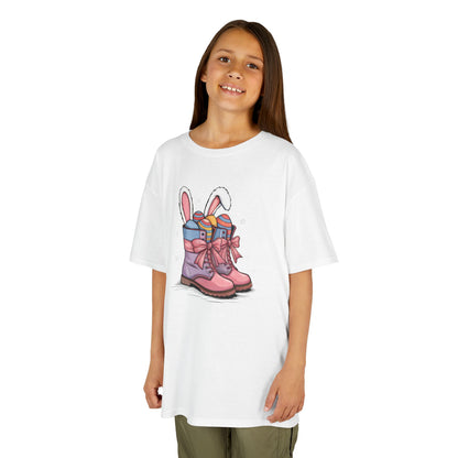 Child wearing a white Easter T-shirt featuring cowgirl boots filled with colorful eggs and bunny ears. A stylish Easter look. Hop into the season in style and shop Easter shirts online today!