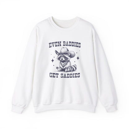 Front view of a white sweater jumper with the text "Even Baddies Get Saddies" and a cartoon raccoon illustration. Part of the Vivid Divergence Sensory Friendly Unisex Sweater Jumper Range.