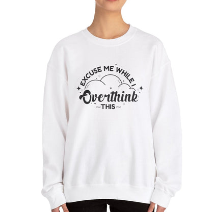 Model wearing a white sweater jumper with the text "Excuse Me While I Overthink This" in black lettering. Part of the Vivid Divergence Sensory Friendly Unisex Sweater Jumper Range.