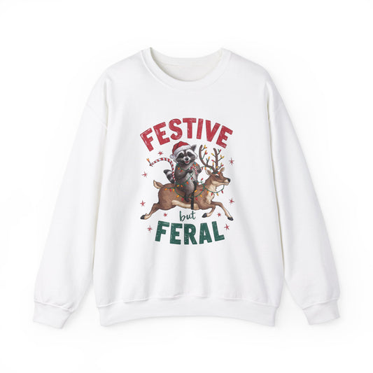 Front view of a white sweatshirt featuring a festive illustration of a raccoon (trash panda) holding Christmas lights and the text "Festive but Feral." Part of the Vivid Divergence Sensory Friendly Unisex Sweater Jumper Range.