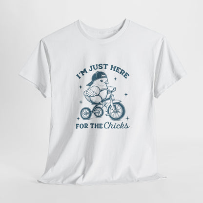 White T-shirt hanging, showcasing a playful "I'm Just Here for the Chicks" text with a chick on a bicycle, a lighthearted and festive holiday tee. Hop into the season in style and shop Easter shirts online today!