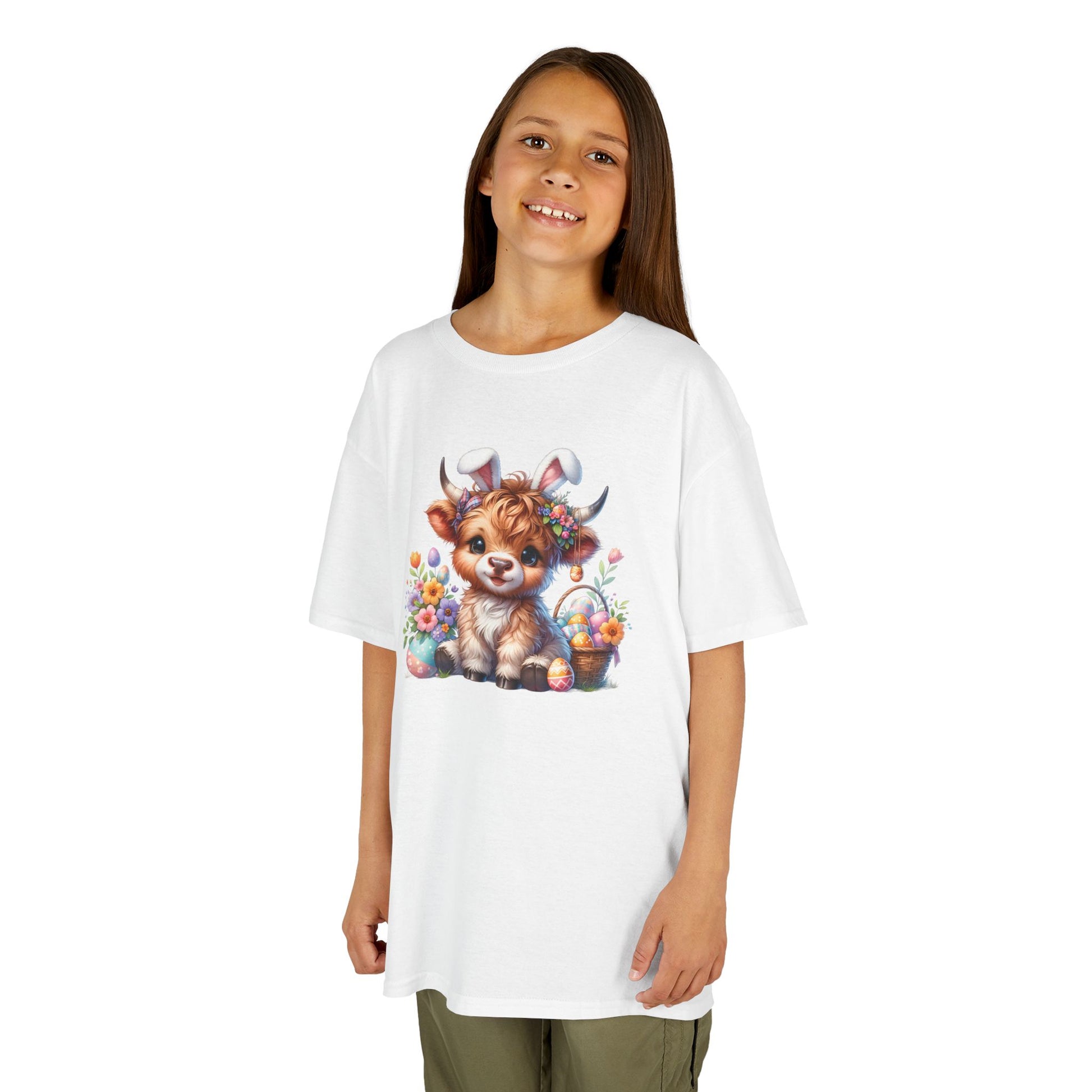 Child wearing a white Easter T-shirt with a Highland cow, colorful eggs, and spring florals, a festive and stylish choice. Hop into the season in style and shop Easter shirts online today!