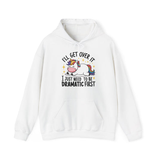 Front view of a white hoodie featuring a cartoon unicorn lying dramatically on a couch with the text "I'll Get Over It, I Just Need To Be Dramatic First." Part of the Vivid Divergence Sensory Friendly Unisex Hoodie Range.