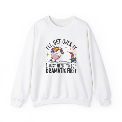 Front view of a white sweater jumper with the text "I’ll Get Over It, I Just Need To Be Dramatic First" and a cartoon unicorn lying on its side. Part of the Vivid Divergence Sensory Friendly Unisex Sweater Jumper Range.