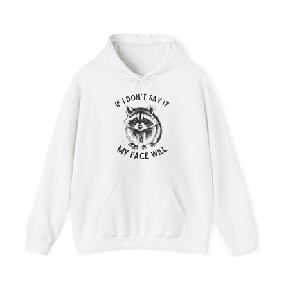 Front view of a white hoodie featuring a raccoon graphic with the text "If I Don't Say It, My Face Will." Part of the Vivid Divergence Sensory Friendly Unisex Hoodie Range.