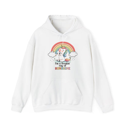 Front view of a white hoodie featuring a grumpy-looking unicorn with wings under a rainbow, with the text "I'm a Freakin' Ray of Sunshine." Part of the Vivid Divergence Sensory Friendly Unisex Hoodie Range.