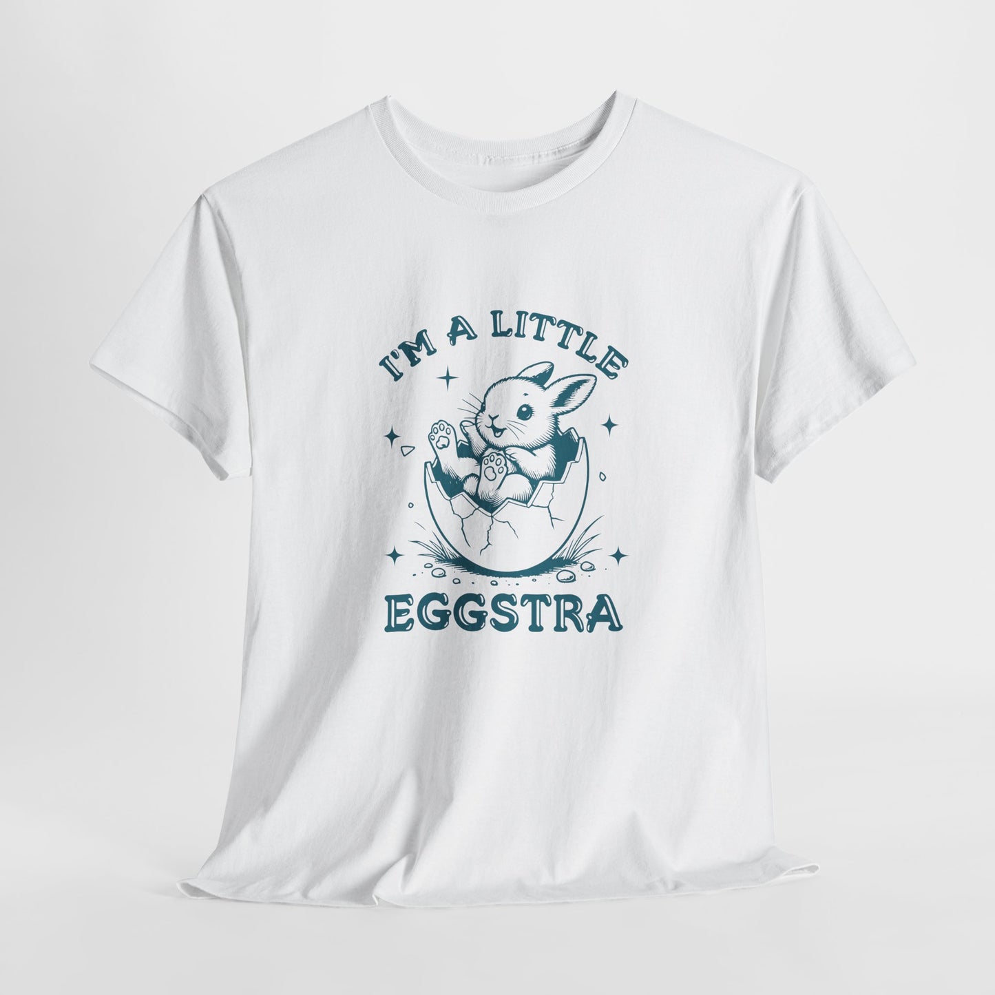 White Easter T-shirt hanging, featuring a cute bunny and "I'm A Little Eggstra" text in a blue design, perfect for a fun holiday look. Hop into the season in style and shop Easter shirts online today!
