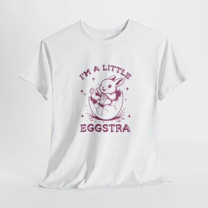 White Easter T-shirt hanging, showcasing a playful bunny and "I'm A Little Eggstra" text in a pink design, a stylish and festive choice. Hop into the season in style and shop Easter shirts online today!