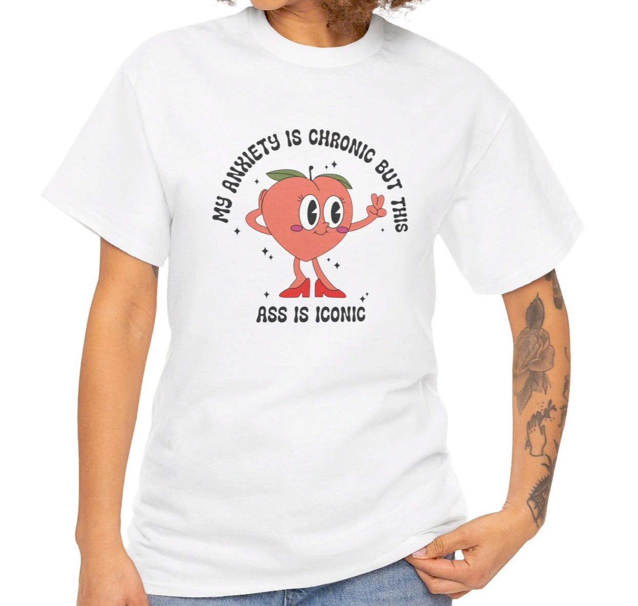 Close-up of a person wearing a white T-shirt with the text "My Anxiety Is Chronic But This Ass Is Iconic" paired with a denim jacket. Part of the Vivid Divergence Sensory Friendly Unisex Tees Range.