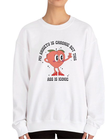 Model wearing a white sweater jumper with the text "My anxiety is chronic but this ass is iconic" and a cartoon peach illustration. Part of the Vivid Divergence Sensory Friendly Unisex Sweater Jumper Range.