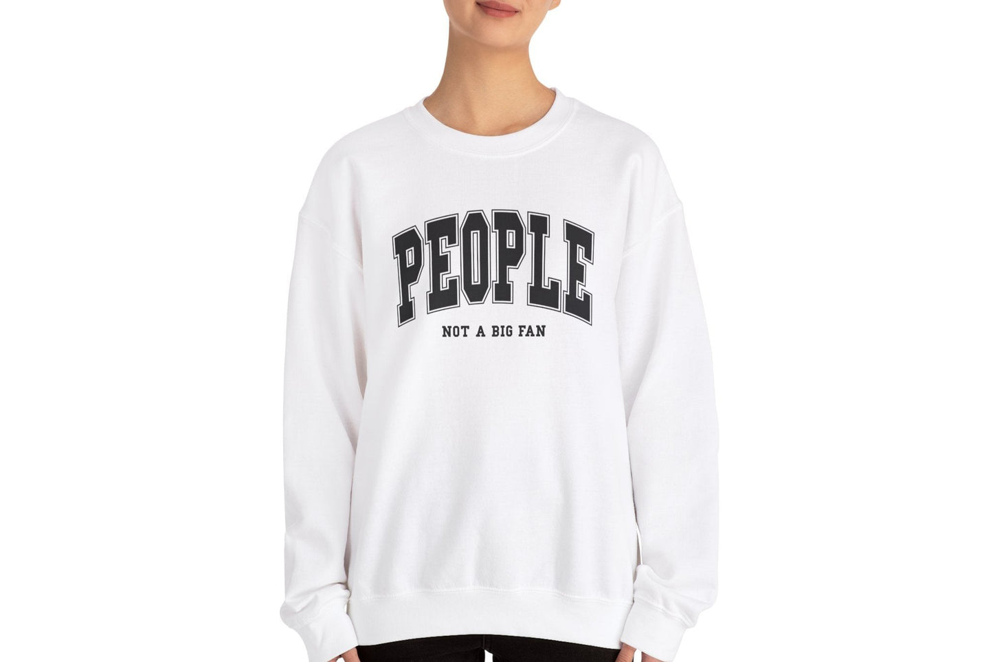 Model wearing a white sweater jumper with the text "People. Not a Big Fan" in bold white lettering. Part of the Vivid Divergence Sensory Friendly Unisex Sweater Jumper Range.