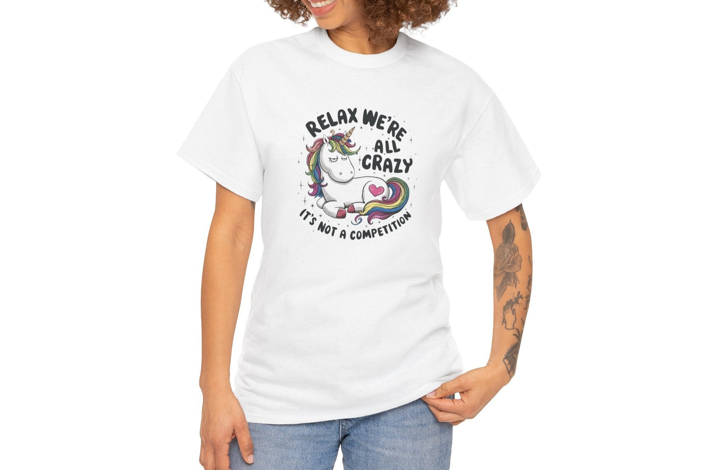 Model wearing a white T-shirt with "Relax, We're All Crazy" and a whimsical cat graphic in black text. Part of the Vivid Divergence Sensory Friendly Unisex Tees Range.
