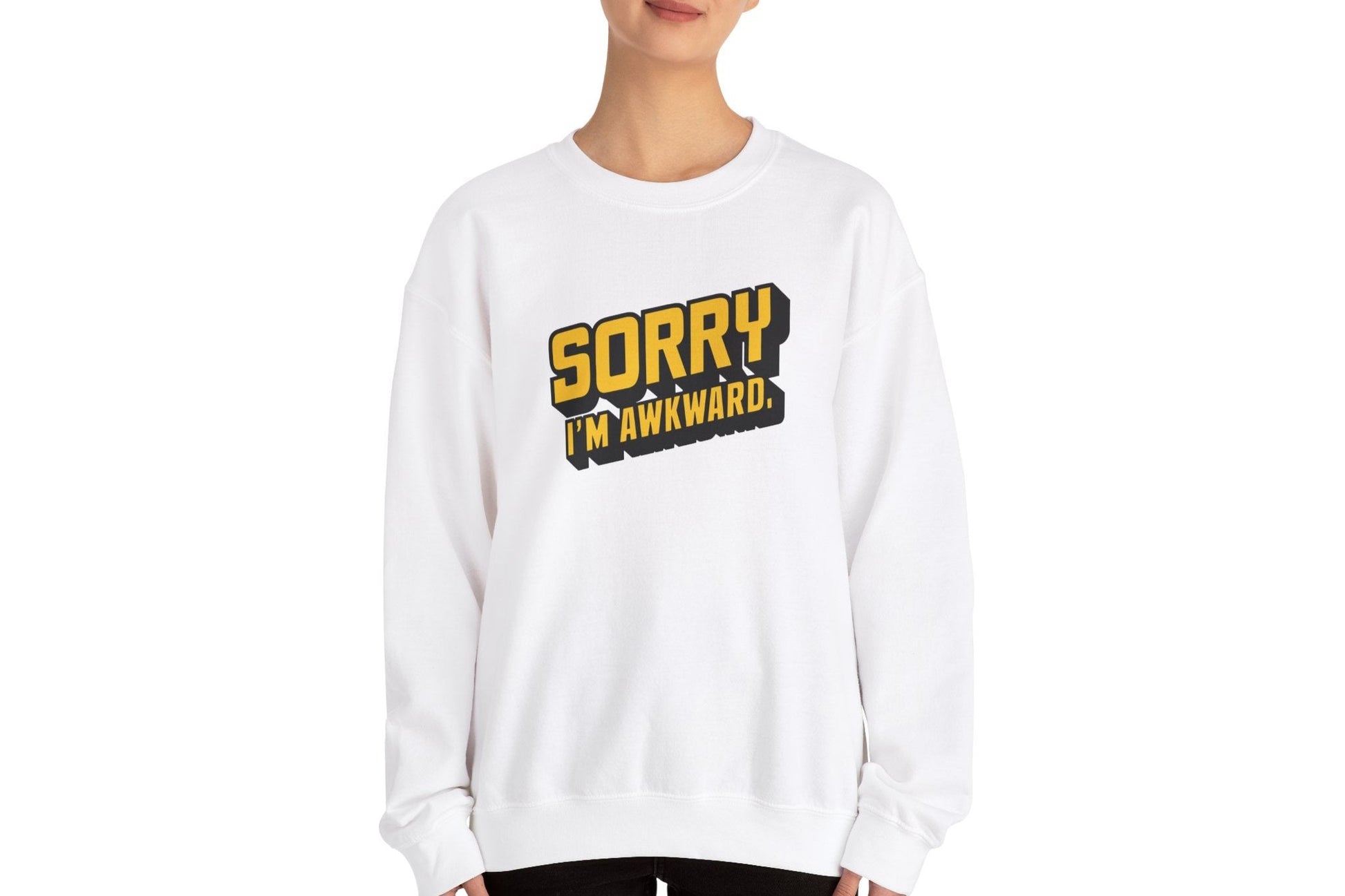 Model wearing a white sweater jumper with the text "Sorry, I'm Awkward." in bold yellow lettering. Part of the Vivid Divergence Sensory Friendly Unisex Sweater Jumper Range.