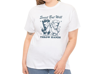 Model with curly hair wearing a white T-shirt featuring "Sweet But Will Throw Hands" text with two dogs in navy blue-tone design. Part of the Vivid Divergence Sensory Friendly Unisex Tees Range.