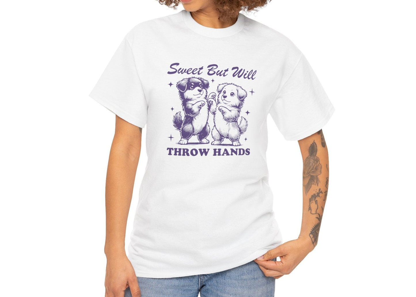Model wearing a white T-shirt featuring "Sweet But Will Throw Hands" text with two dogs in purple-tone design. Part of the Vivid Divergence Sensory Friendly Unisex Tees Range.