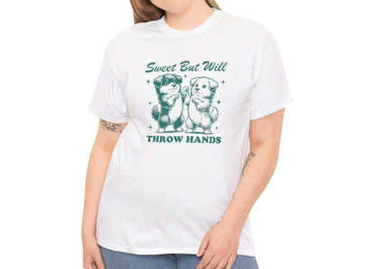 Model wearing a white T-shirt featuring "Sweet But Will Throw Hands" text with two dogs in teal-tone design. Part of the Vivid Divergence Sensory Friendly Unisex Tees Range.
