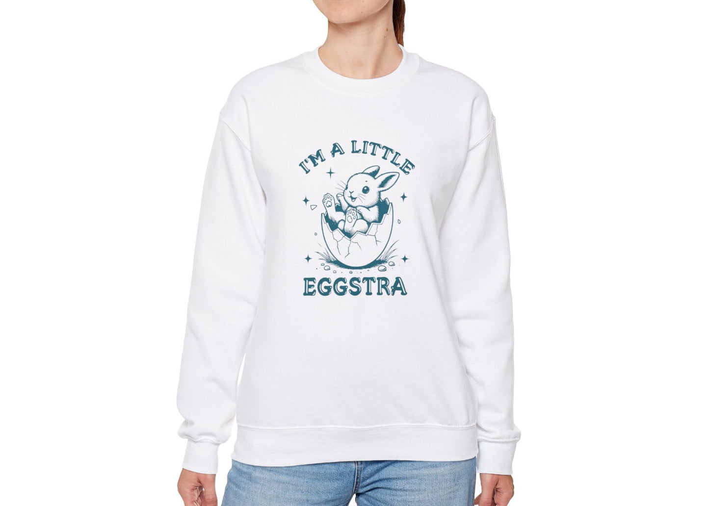 Woman in white sweater jumper featuring teal “I’m a Little Eggstra” Easter bunny. Part of the Vivid Divergence Sensory Friendly Unisex Sweater Jumper Range.

