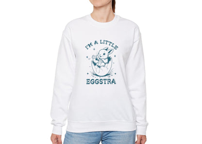 Woman in white sweater jumper featuring teal “I’m a Little Eggstra” Easter bunny. Part of the Vivid Divergence Sensory Friendly Unisex Sweater Jumper Range.
