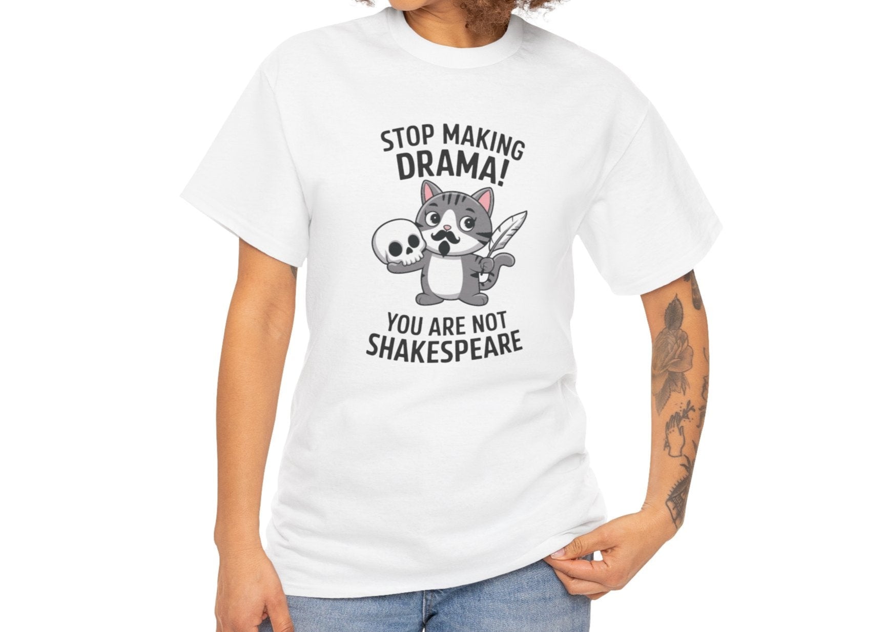 Modeled front view of a white T-shirt featuring a cute cat holding a skull and text that reads "Stop Making Drama! You Are Not Shakespeare." Part of the Vivid Divergence Sensory Friendly Unisex Tees Range.