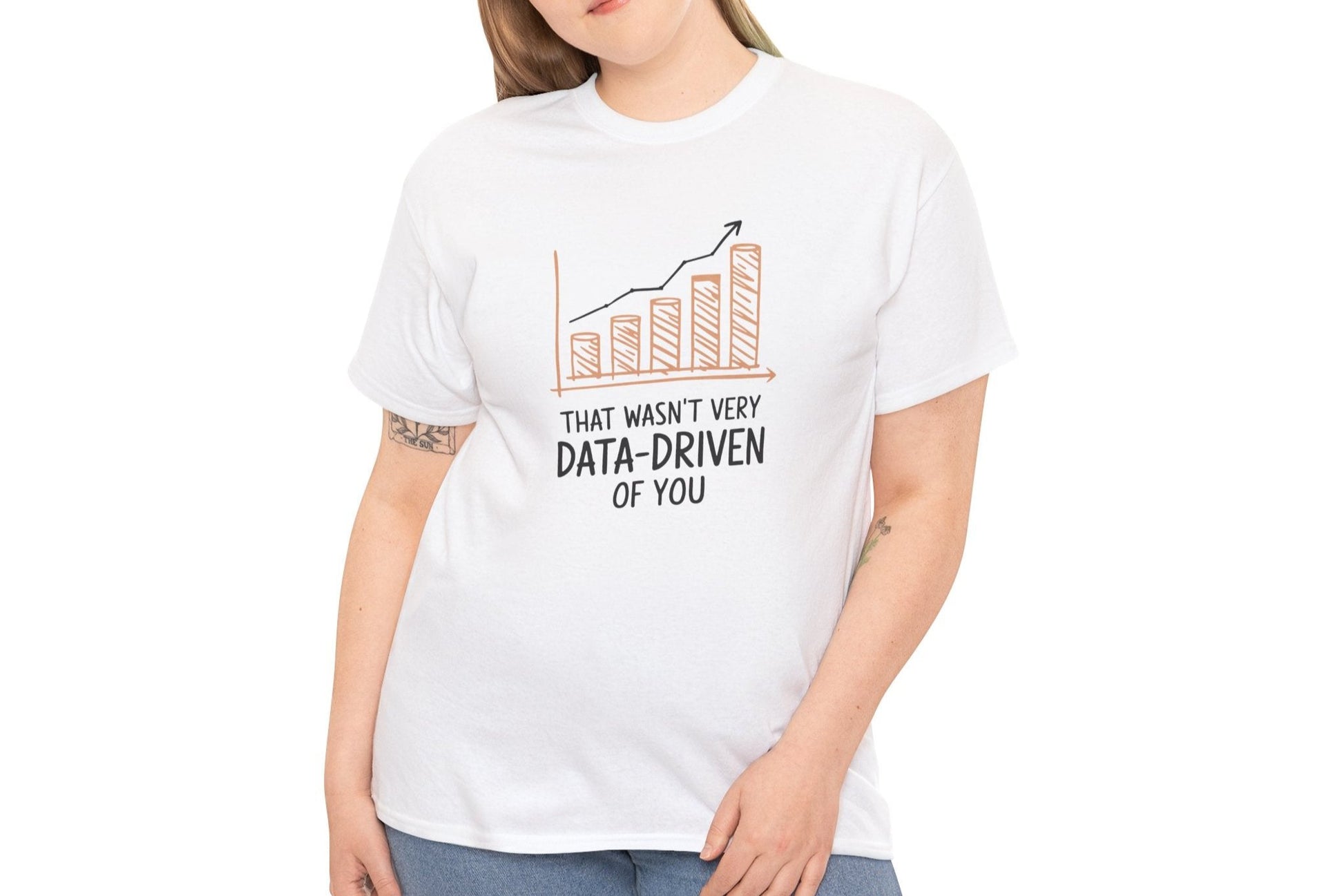 Model wearing a white T-shirt with the text "That Wasn't Very Data-Driven of You" in black, featuring a graphic of a declining bar chart in orange. Part of the Vivid Divergence Sensory Friendly Unisex Tees Range.