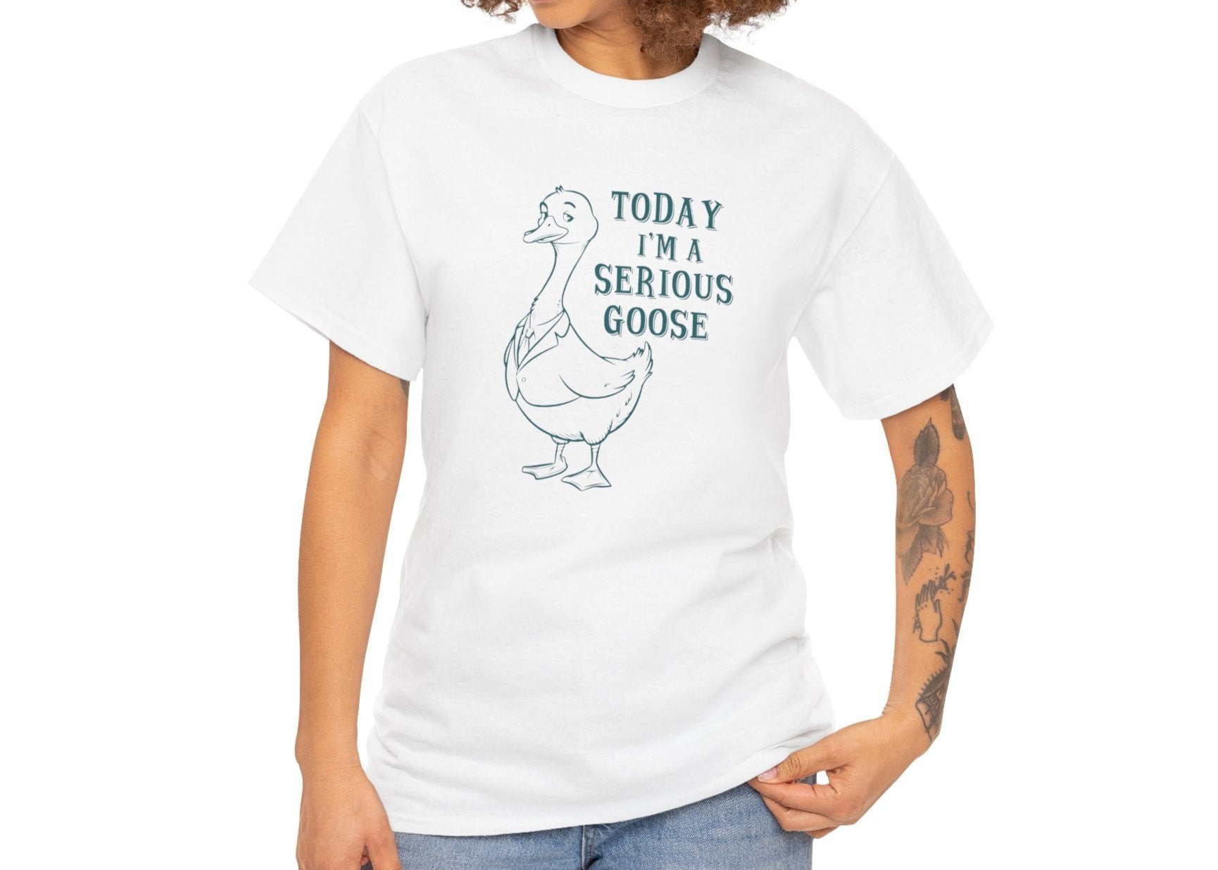 Model wearing a white T-shirt with "Today I'm A Serious Goose" in teal text and a simple goose illustration. Part of the Vivid Divergence Sensory Friendly Unisex Tees Range.
