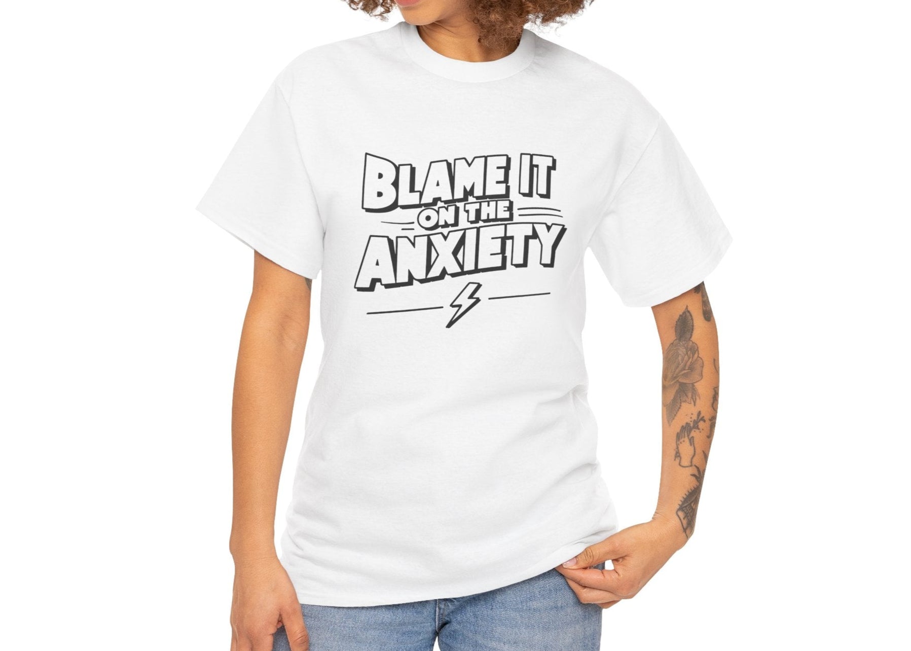 White T-shirt with "Blame It on the Anxiety" text modeled on a person with arms at their sides. Part of the Vivid Divergence Sensory Friendly Unisex Tees Range.