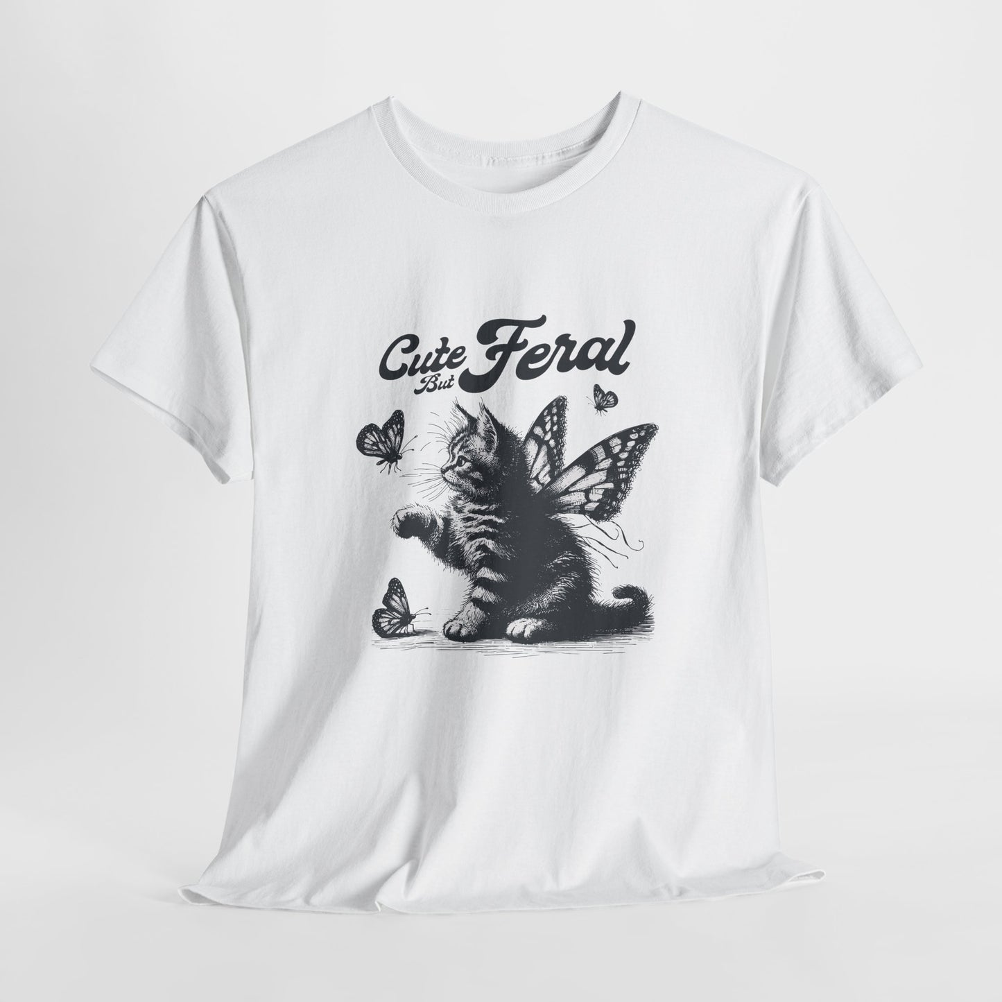 White T-shirt with "Cute but Feral" cat and butterfly design, laid flat on a white background. Part of the Vivid Divergence Sensory Friendly Unisex Tees Range.