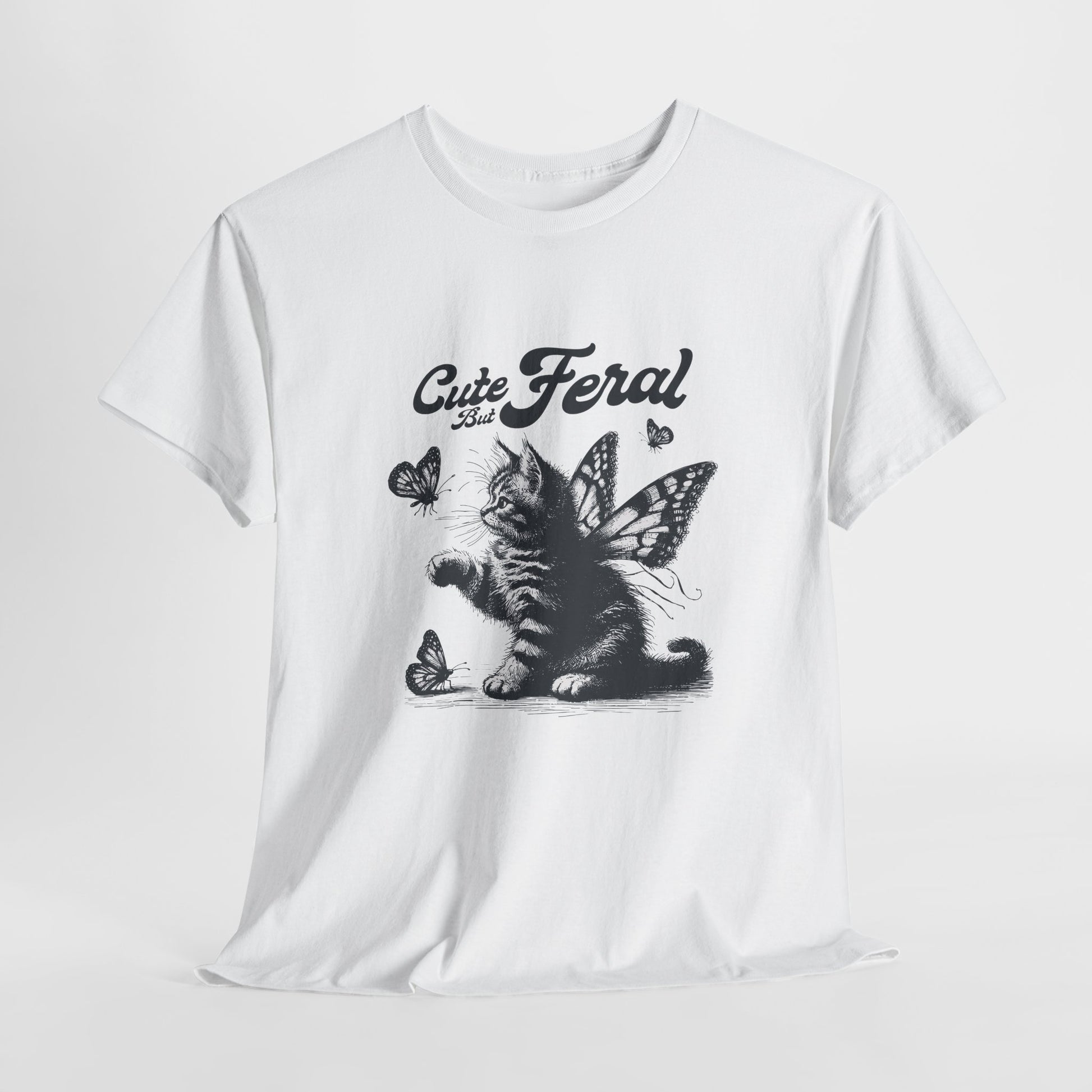 White T-shirt with "Cute but Feral" cat and butterfly design, laid flat on a white background. Part of the Vivid Divergence Sensory Friendly Unisex Tees Range.