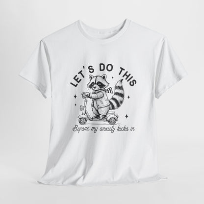 White T-shirt with "Let's Do This Before Anxiety kicks in" raccoon illustration and text, laid flat on a white background. Part of the Vivid Divergence Sensory Friendly Unisex Tees Range.