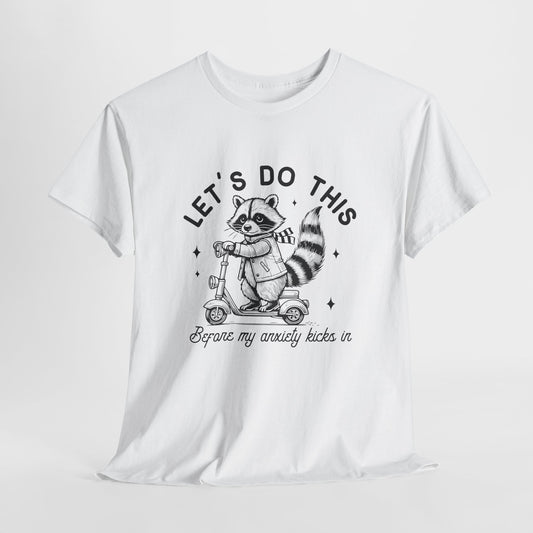 White T-shirt with "Let's Do This Before Anxiety kicks in" raccoon illustration and text, laid flat on a white background. Part of the Vivid Divergence Sensory Friendly Unisex Tees Range.