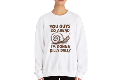 Model wearing a white sweater jumper featuring the text "You Guys Go Ahead, I’m Gonna Dilly Dally" and a cartoon snail illustration. Part of the Vivid Divergence Sensory Friendly Unisex Sweater Jumper Range.