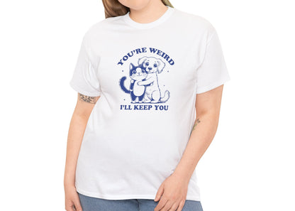 Model wearing a white T-shirt with a "You're Weird, I'll Keep You" design featuring a dog hugging a cat in navy blue. Part of the Vivid Divergence Sensory Friendly Unisex Tees Range.