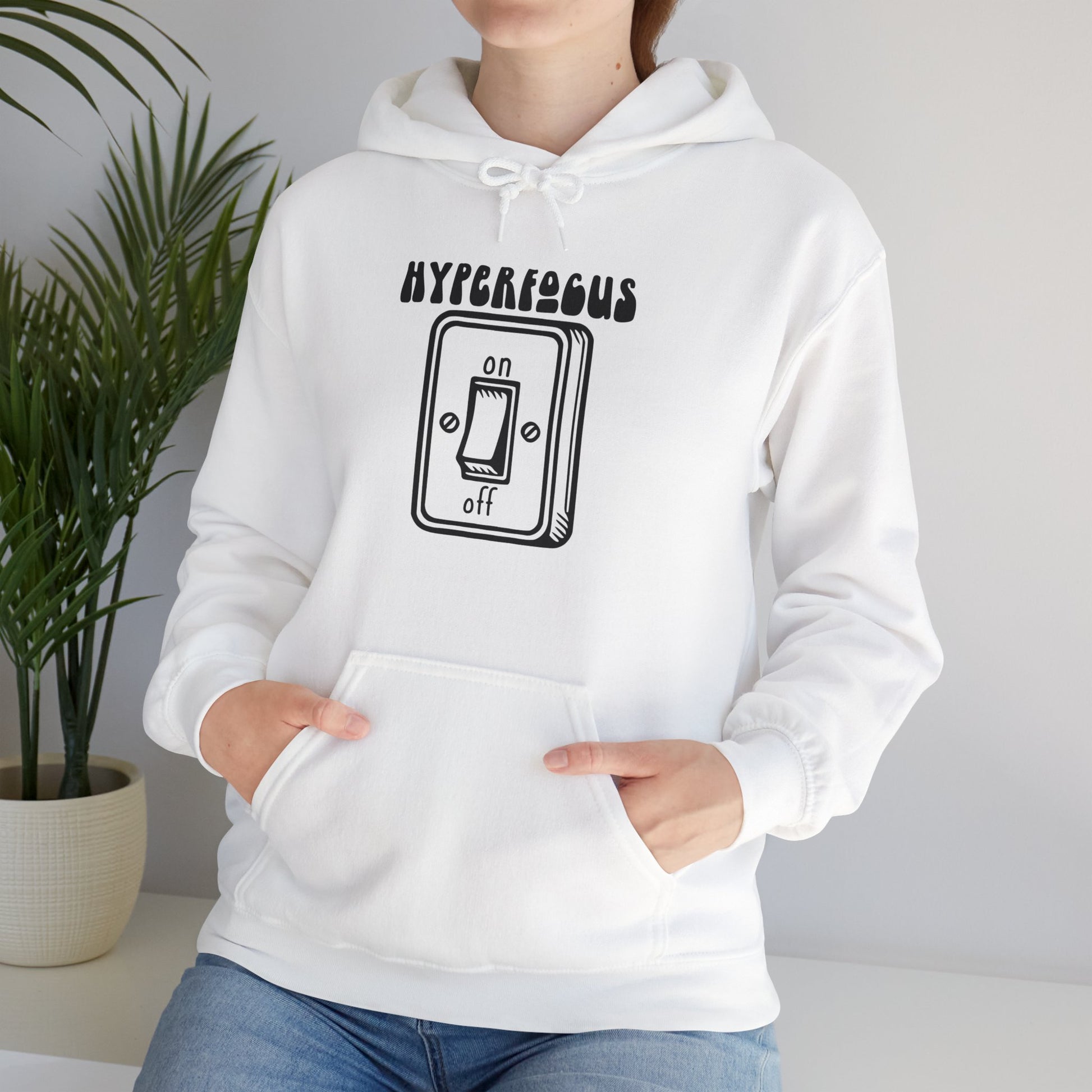 Model wearing a white hoodie featuring the text "Hyperfocus" and an illustration of a toggle switch turned on. Part of the Vivid Divergence Sensory Friendly Unisex Hoodie Range.