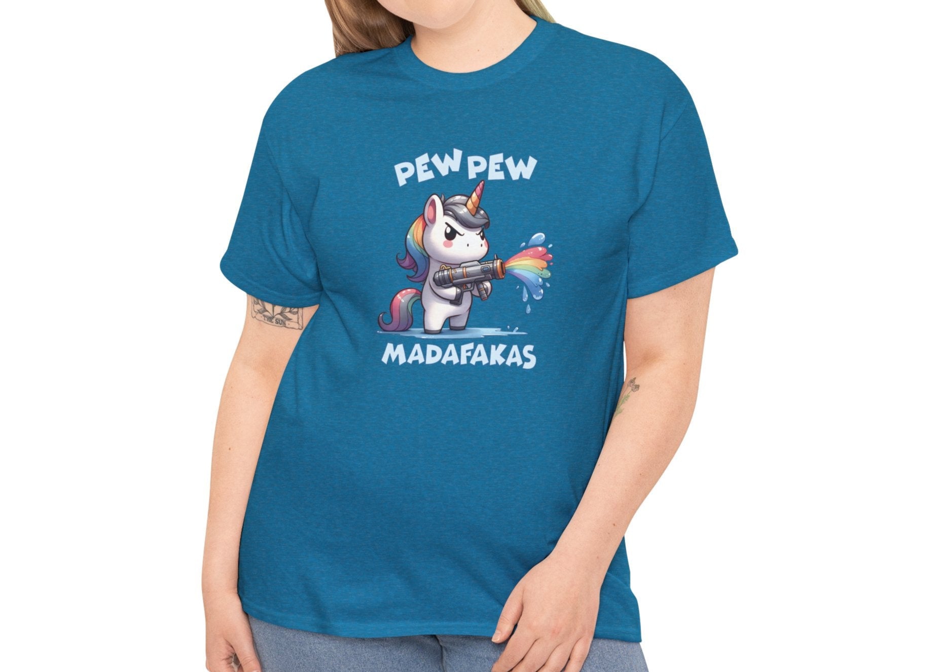 Woman wearing a teal T-shirt with a "Pew Pew Madafakas" unicorn graphic, styled casually. Part of the Vivid Divergence Sensory Friendly Unisex Tees Range.