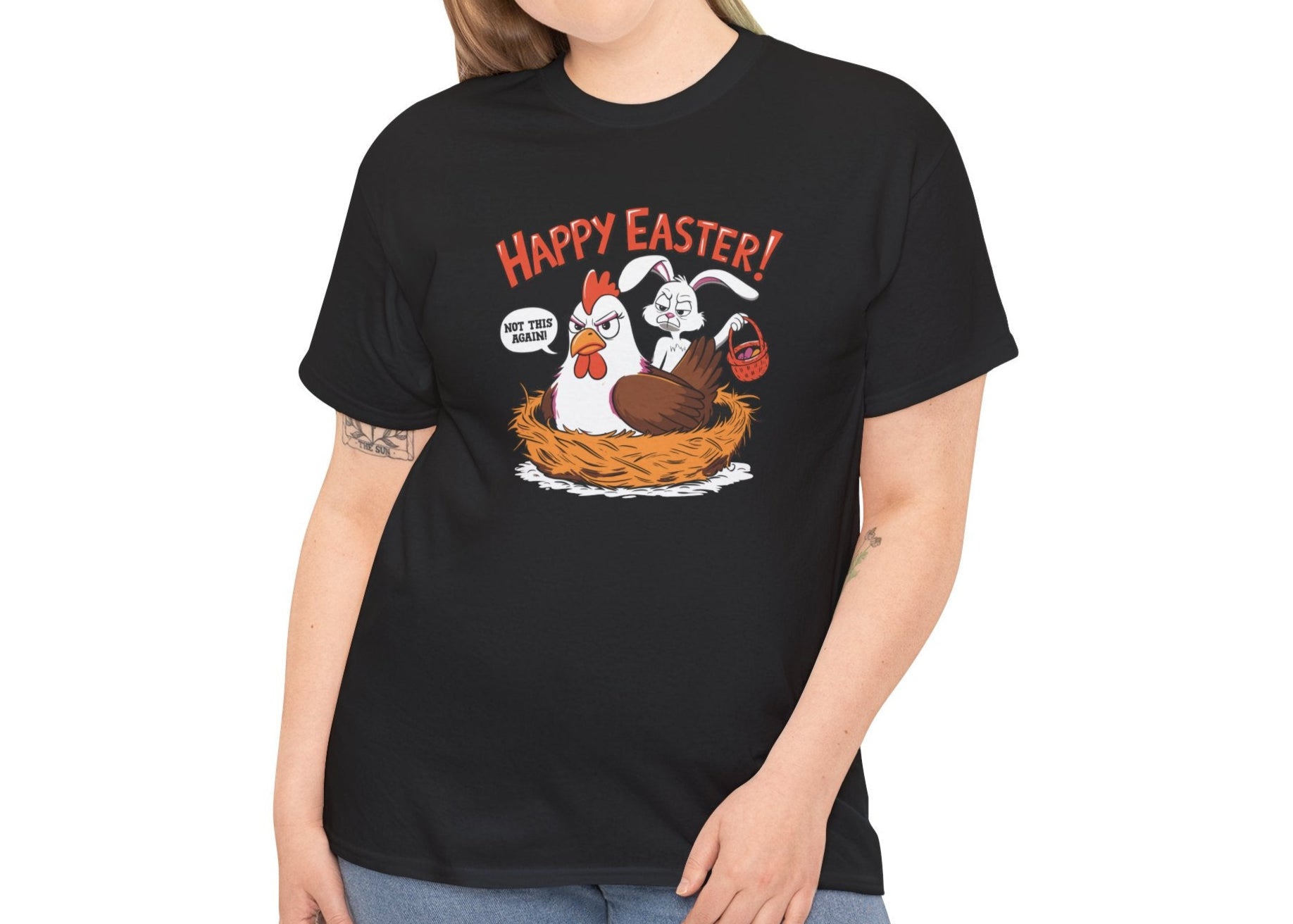 Woman wearing a black Easter T-shirt featuring a guilty bunny in a hen’s nest with "Happy Easter" text, a hilarious holiday outfit. Hop into the season in style and shop Easter shirts online today!
