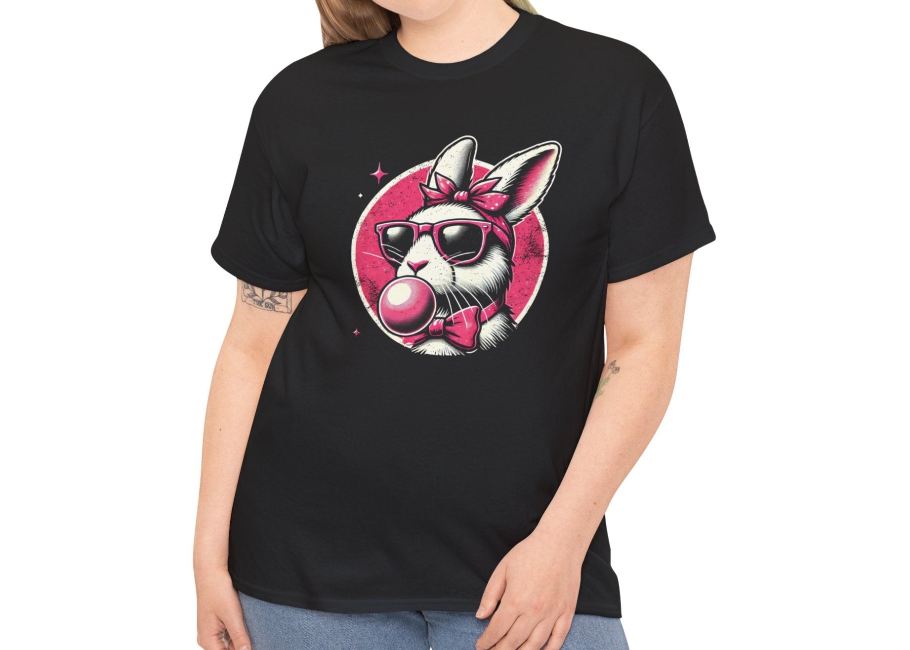 Woman wearing a black Easter T-shirt featuring a retro bunny with sunglasses and bubblegum, a trendy and cool holiday outfit. Hop into the season in style and shop Easter shirts online today!