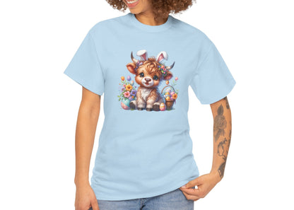 Woman wearing a light blue Easter T-shirt showcasing a fluffy Highland cow with colorful eggs and flowers, a perfect festive choice. Hop into the season in style and shop Easter shirts online today!