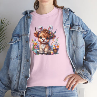 Woman wearing a light pink Easter T-shirt showcasing a fluffy Highland cow with colorful eggs and flowers, a perfect festive choice. Hop into the season in style and shop Easter shirts online today!