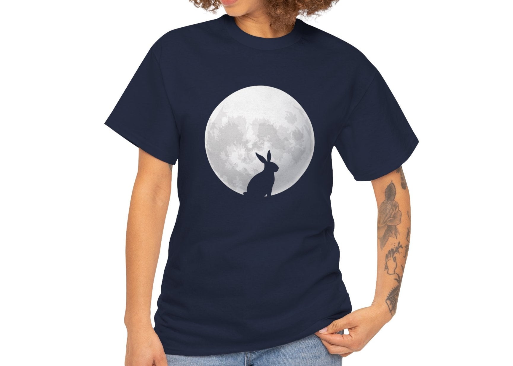 Woman wearing a navy blue Easter T-shirt showcasing a rabbit gazing at a glowing full moon, perfect for moon lovers and folklore fans. Hop into the season in style and shop Easter shirts online today!
