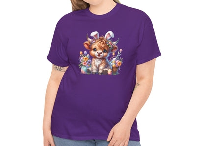 Woman wearing a purple Easter T-shirt decorated with a sweet Highland cow surrounded by spring flowers, a stylish and fun holiday look. Hop into the season in style and shop Easter shirts online today!