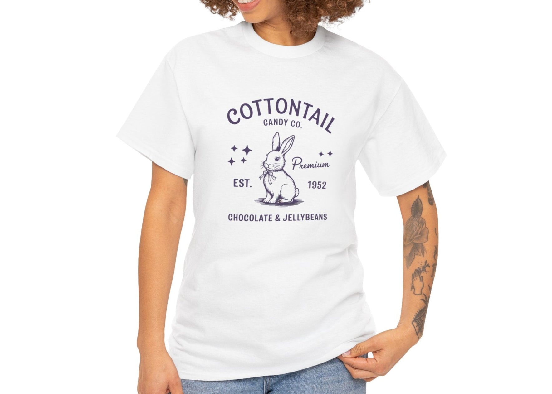 Woman wearing a white Easter T-shirt featuring a vintage "Cottontail Candy Co." bunny logo, a charming and nostalgic holiday style. Hop into the season in style and shop Easter shirts online today!