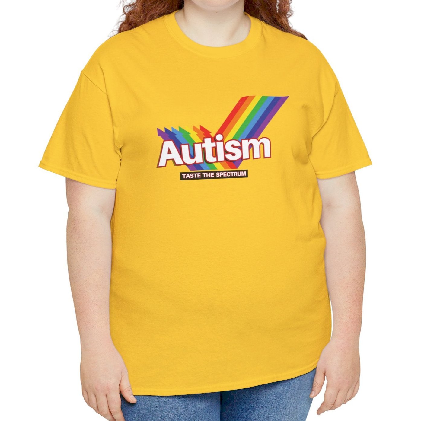 Side view of a yellow T-shirt worn by a person, featuring the phrase "Autism" in a Skittles-inspired design and a rainbow graphic. Part of the Vivid Divergence Sensory Friendly Unisex Tees Range.